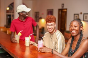 Guests with drinks at the bar counter, a barman serving.