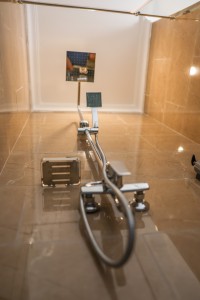 An en-suite bathroom with basin, mirror and a glazed shower, tiled in green marble.