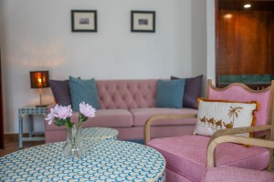 A guest room with king or twin beds, bedside lamps and curtained windows onto the garden.