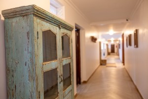 Interior detail at the hotel: hanging cowbells, framed pictures and a chequerboard corridor floor.