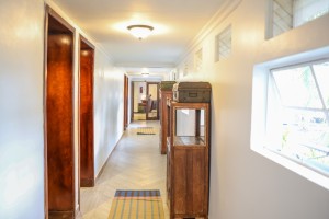 Interior detail at the hotel: hanging cowbells, framed pictures and a chequerboard corridor floor.