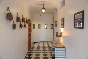 Interior detail at the hotel: hanging cowbells, framed pictures and a chequerboard corridor floor.