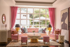 The lobby lounge, with sofas and armchairs beneath a wall of tall windows onto the garden.
