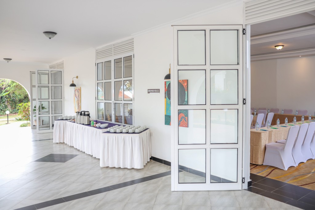 A refreshment table laid with flasks and cups, seen through open glazed doors from the adjoining room.