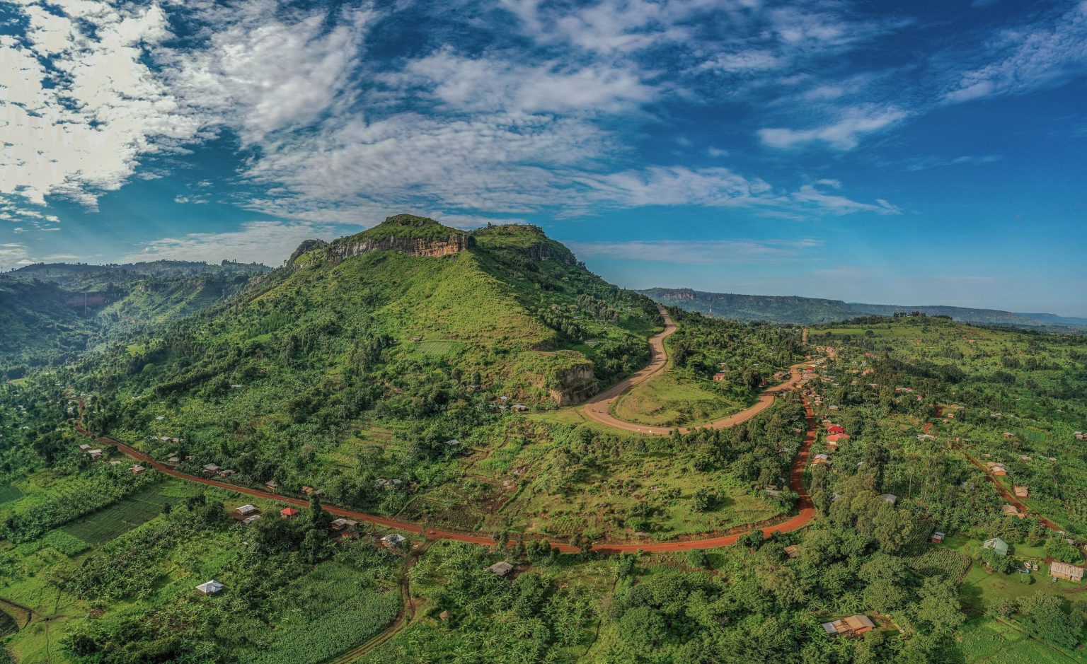 An aerial view of a flat-topped hill and red earth roads in the Kapchorwa highlands.
