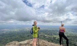Two walkers on the grassy edge of Wanale Ridge above the plains outside Mbale.